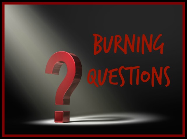 A red question mark in the dark lit by a single, yellow spotlight.